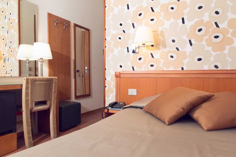 Camera da letto moderna con carta da parati floreale e arredamento in legno.
